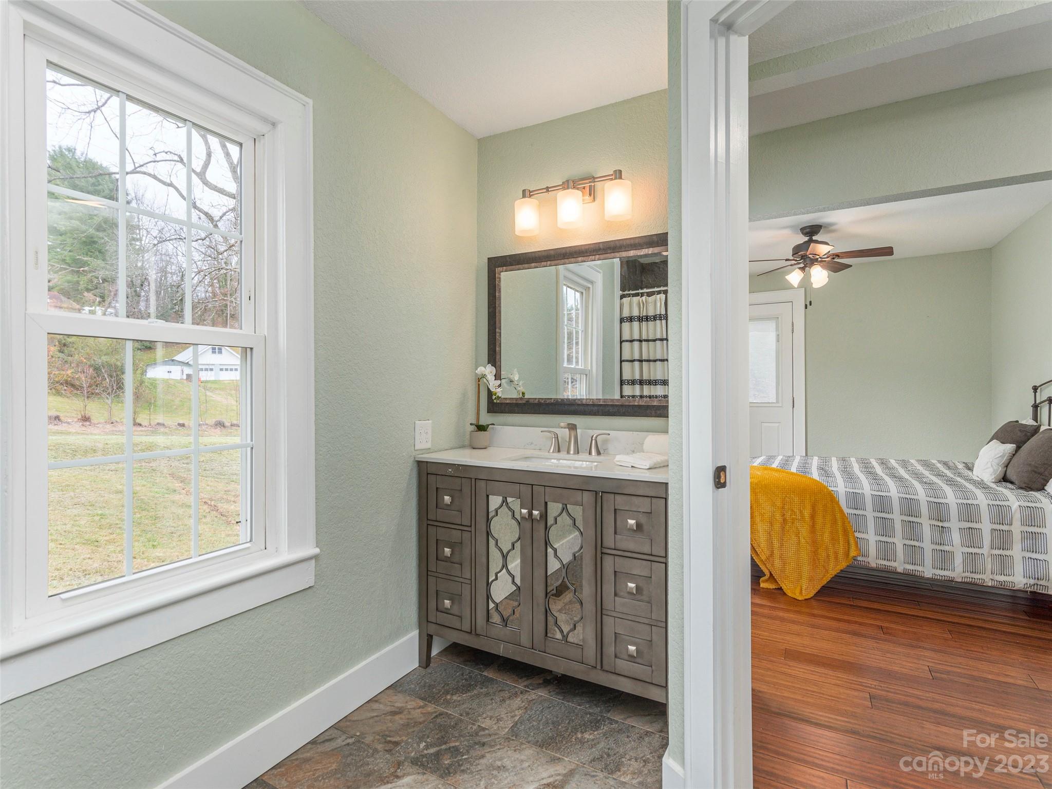 2117 Old Clyde Road Clyde, NC 28721 - Photo 5 of 24 a bathroom with a granite countertop sink and a mirror