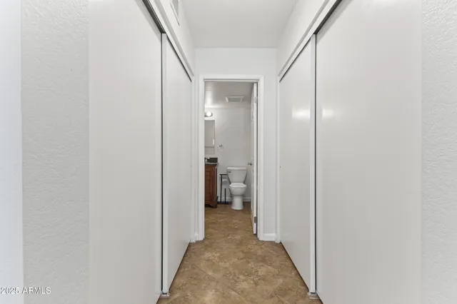 a view of a hallway with wooden shelves