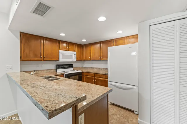 a kitchen with stainless steel appliances granite countertop refrigerator sink stove microwave and cabinets