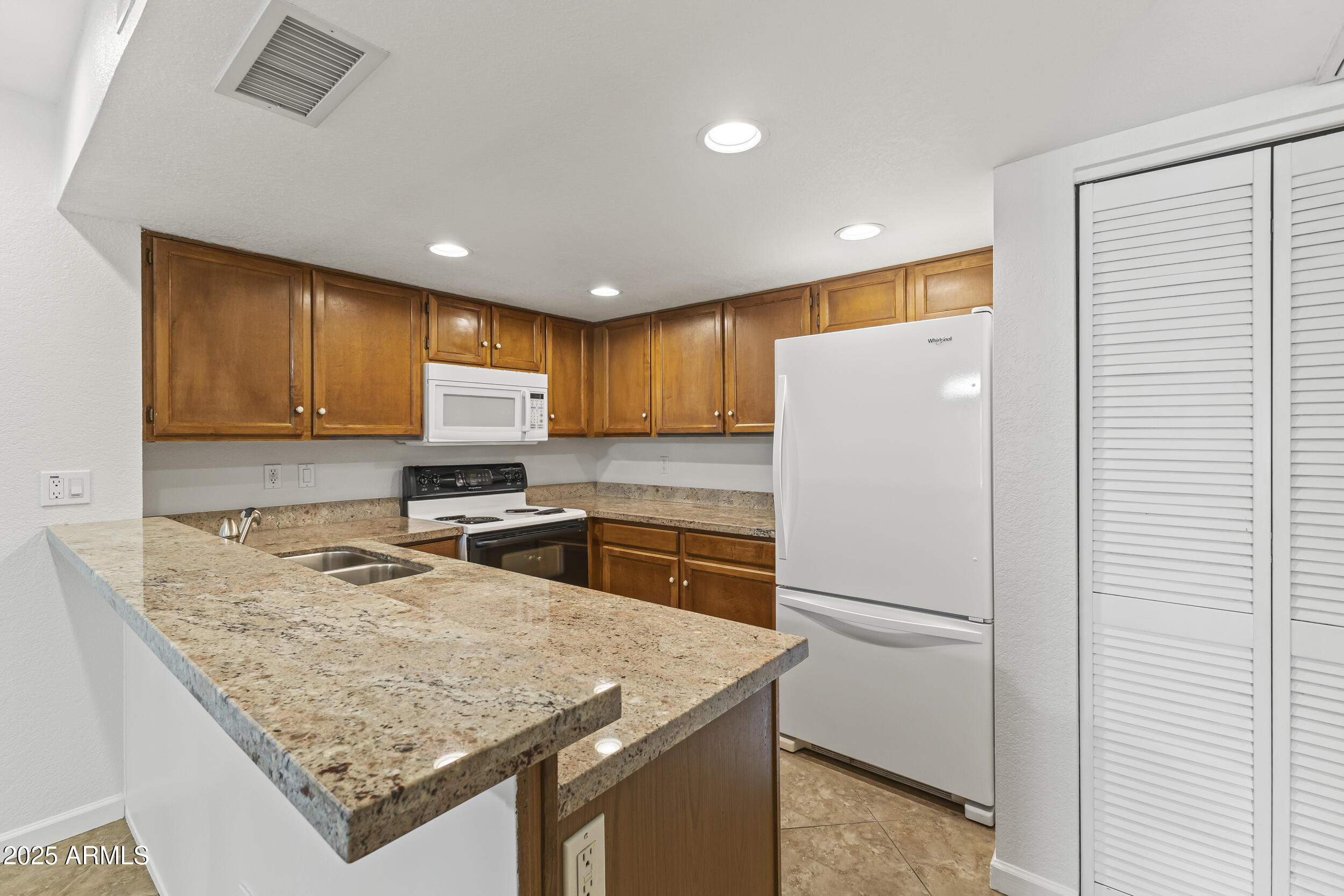 4730 West Northern Avenue, Unit 1158 Glendale, AZ 85301 - Photo 6 of 23 a kitchen with stainless steel appliances granite countertop refrigerator sink stove microwave and cabinets