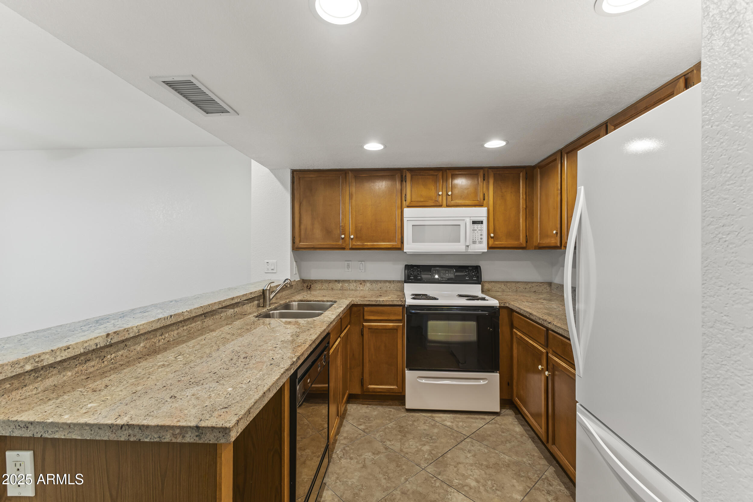 4730 West Northern Avenue, Unit 1158 Glendale, AZ 85301 - Photo 7 of 23 a kitchen with stainless steel appliances granite countertop refrigerator sink and stove