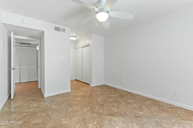 an empty room with a fan & a fan