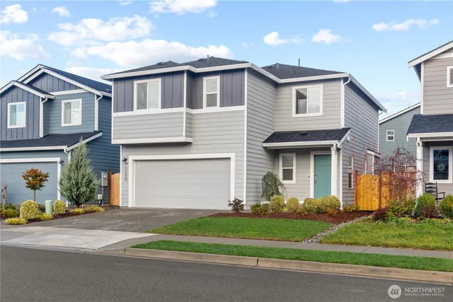 a front view of a house with a garden and garage