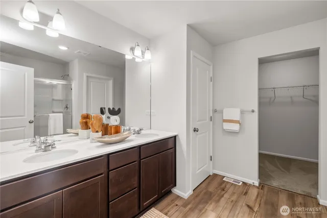 a bathroom with a double vanity sink a mirror and a shower