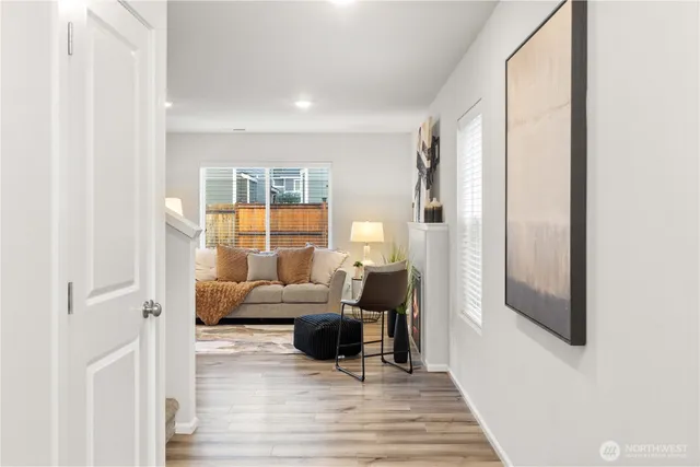 a living room with furniture large window and wooden floor