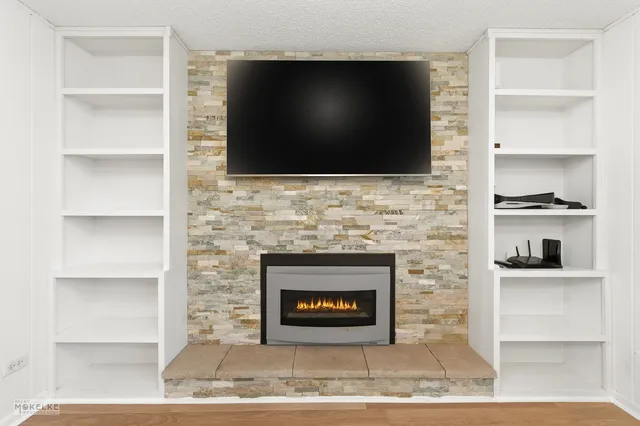 a living room with a fireplace and a flat screen tv