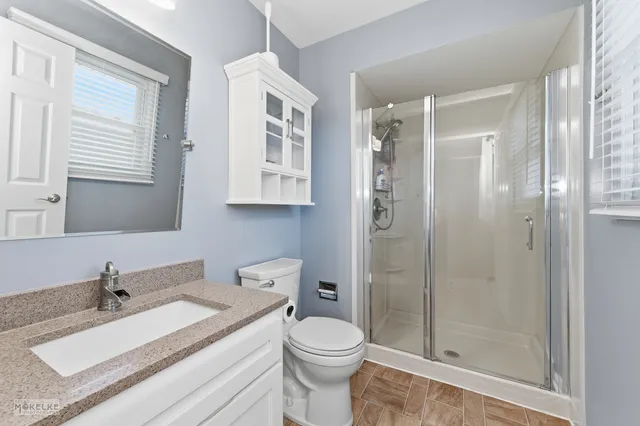 a bathroom with a granite countertop sink toilet and shower