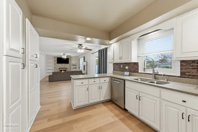 a kitchen with granite countertop a sink stainless steel appliances and cabinets