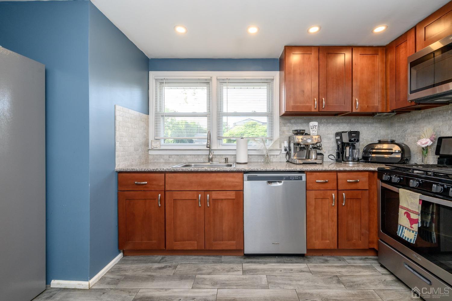 60 Ocean Boulevard Old Bridge, NJ 07735 - Photo 11 of 25 a kitchen with stainless steel appliances granite countertop a stove a sink dishwasher and a microwave oven with cabinets