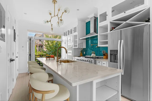 a kitchen with stainless steel appliances granite countertop a table chairs and a refrigerator