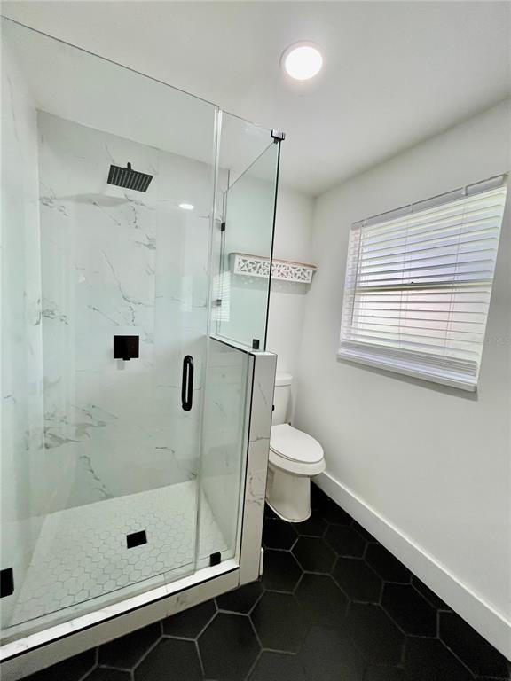 2327 West Beach Street Tampa, FL 33607 - Photo 13 of 15 a bathroom with a shower a toilet and a window