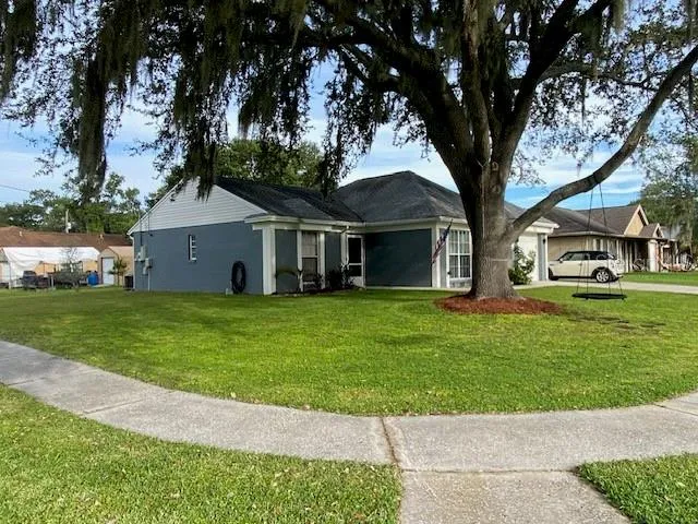 a front view of a house with a garden and trees
