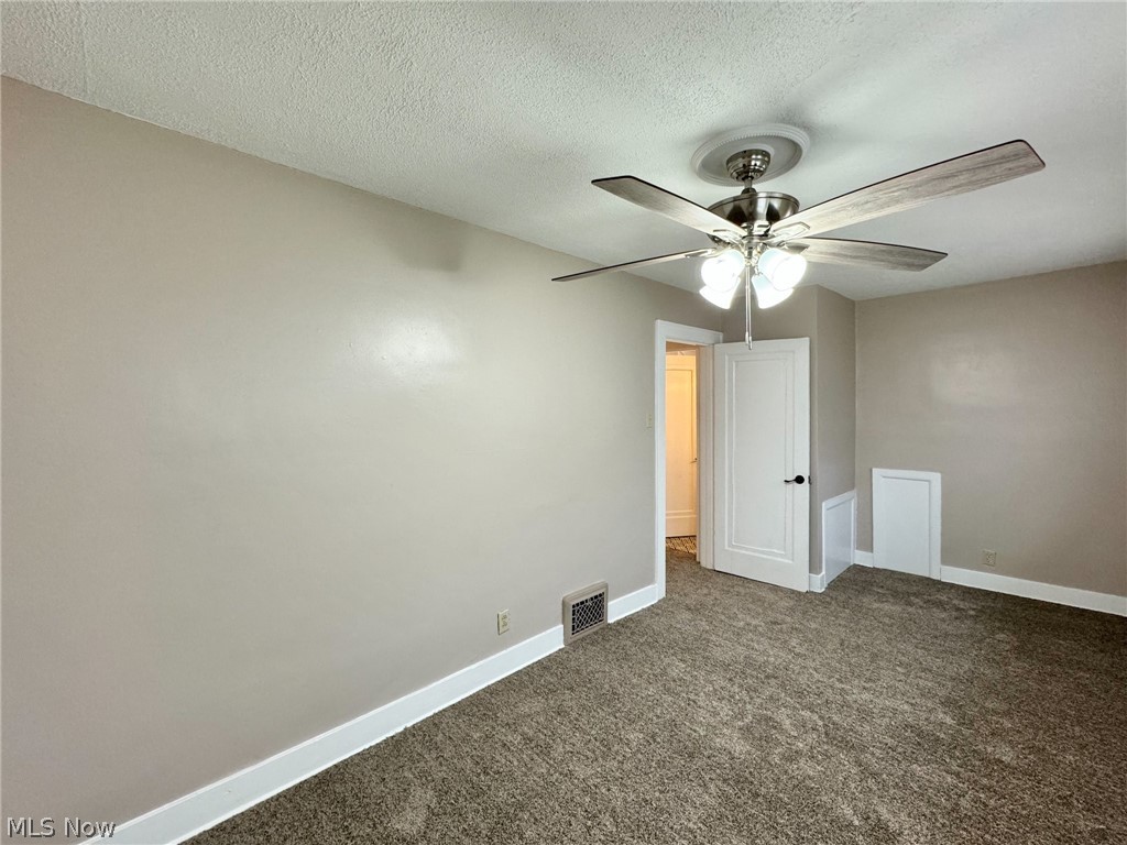 507 Canton Road Wintersville, OH 43953 - Photo 32 of 45 Carpeted spare room featuring a textured ceiling and ceiling fan