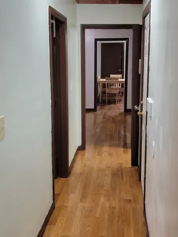 a view of a hallway with wooden shelves