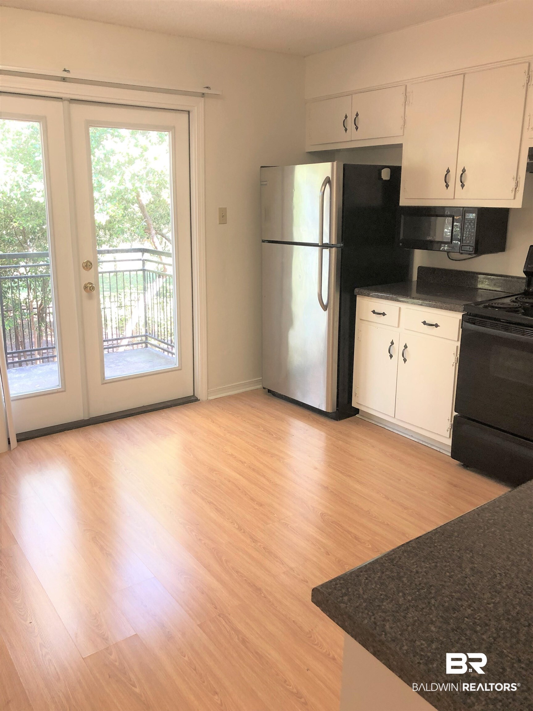 4009 Old Shell Road, Unit C12 Mobile, AL 36608 - Photo 5 of 11 Kitchen with french doors, stainless steel refrigerator, white cabinetry, light hardwood / wood-style flooring, and black range with electric stovetop