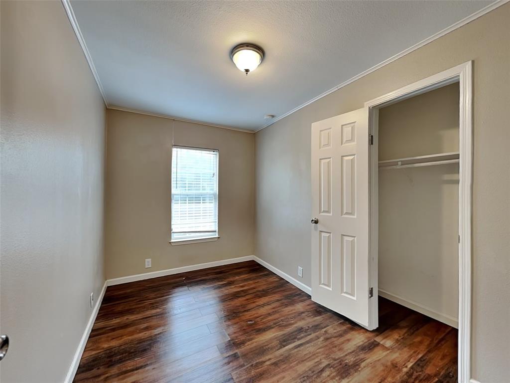 1414 Record Crossing Road Dallas, TX 75235 - Photo 14 of 15 Unfurnished bedroom featuring crown molding, wood finished floors, and a closet