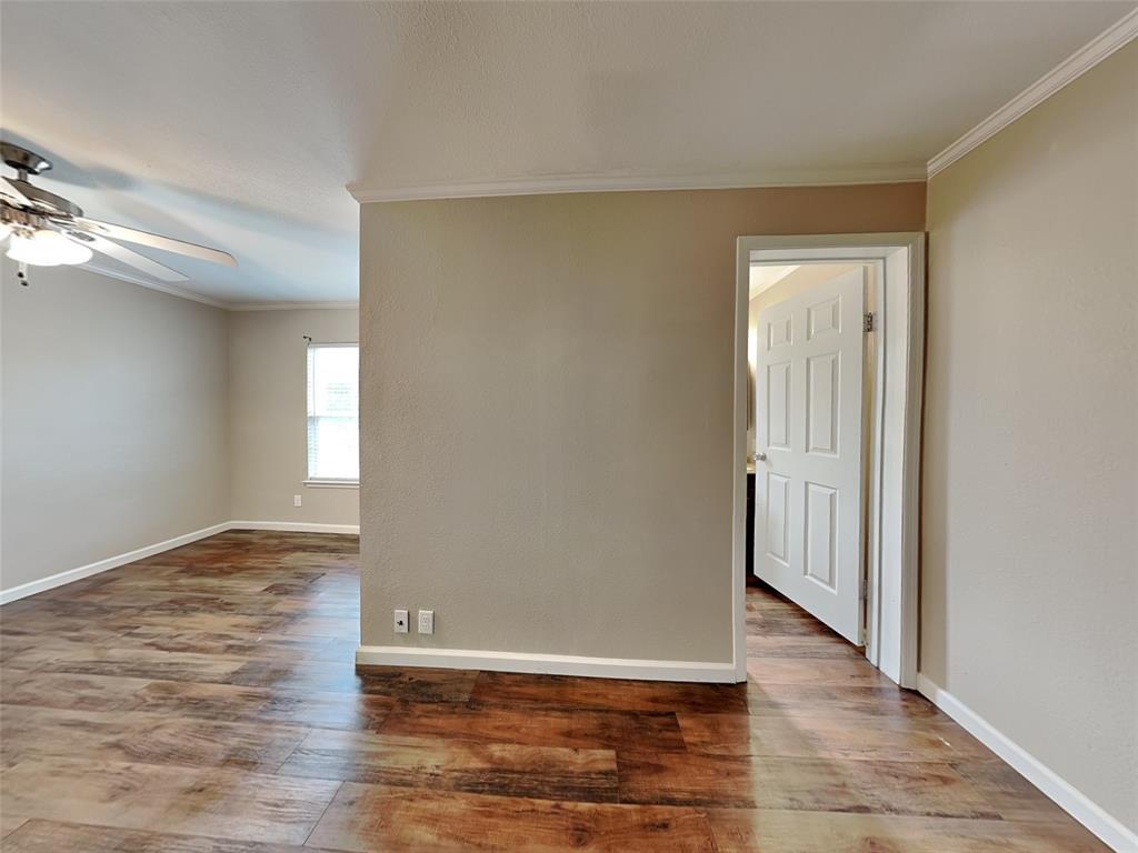 1414 Record Crossing Road Dallas, TX 75235 - Photo 7 of 15 Empty room featuring ornamental molding, a ceiling fan, and wood finished floors