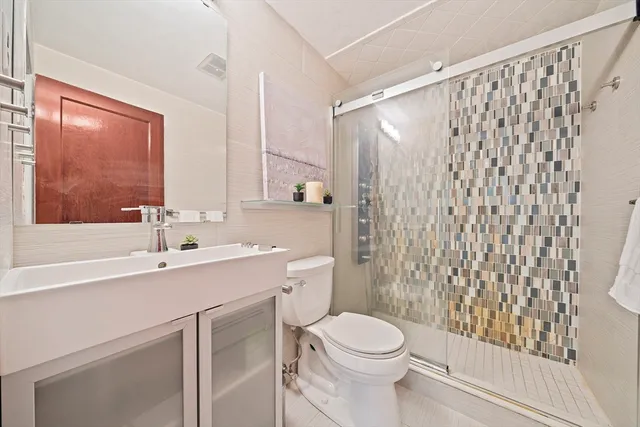 a bathroom with a sink a toilet and shower