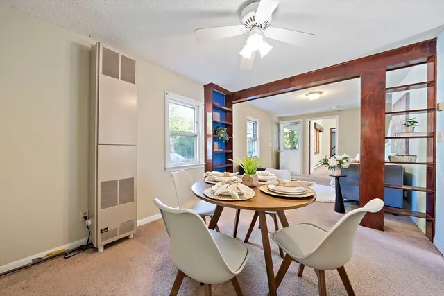 a dining room with furniture a chandelier and wooden floor