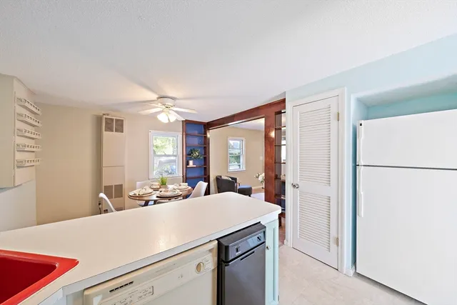 a room with a refrigerator a sink and a large mirror