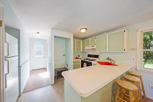 a view of kitchen with stainless steel appliances granite countertop a refrigerator and a stove top oven