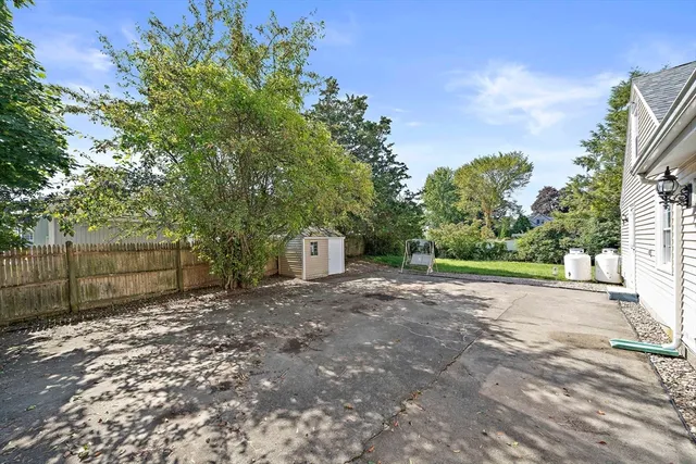 a view of a yard with trees in front of it