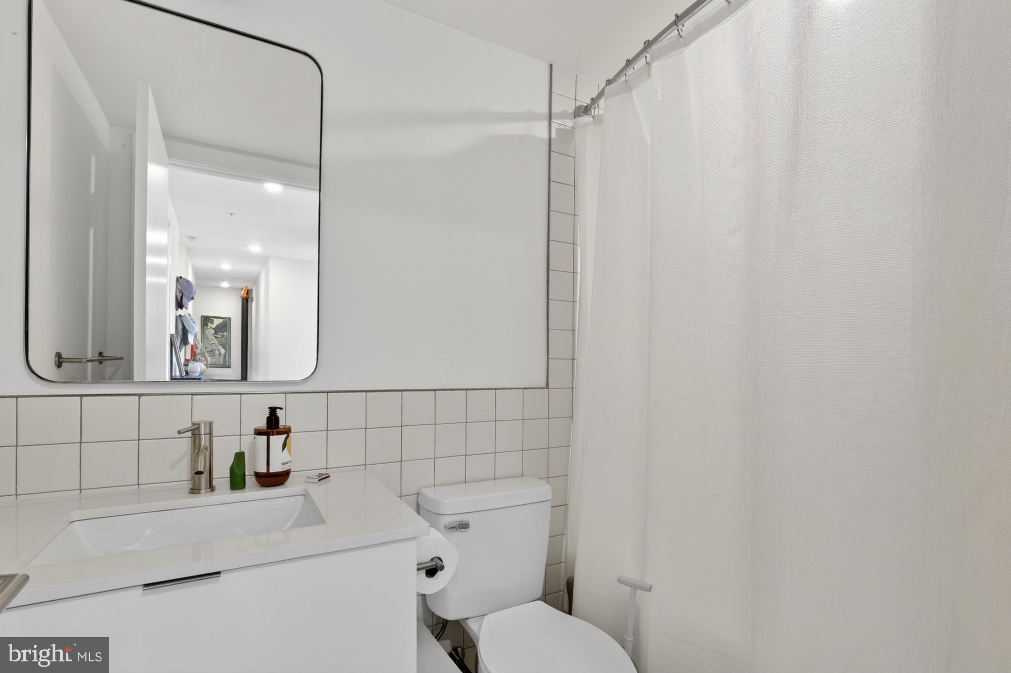 2007 Cambridge Street, Unit 9 Philadelphia, PA 19130 - Photo 14 of 33 a bathroom with a sink mirror and toilet
