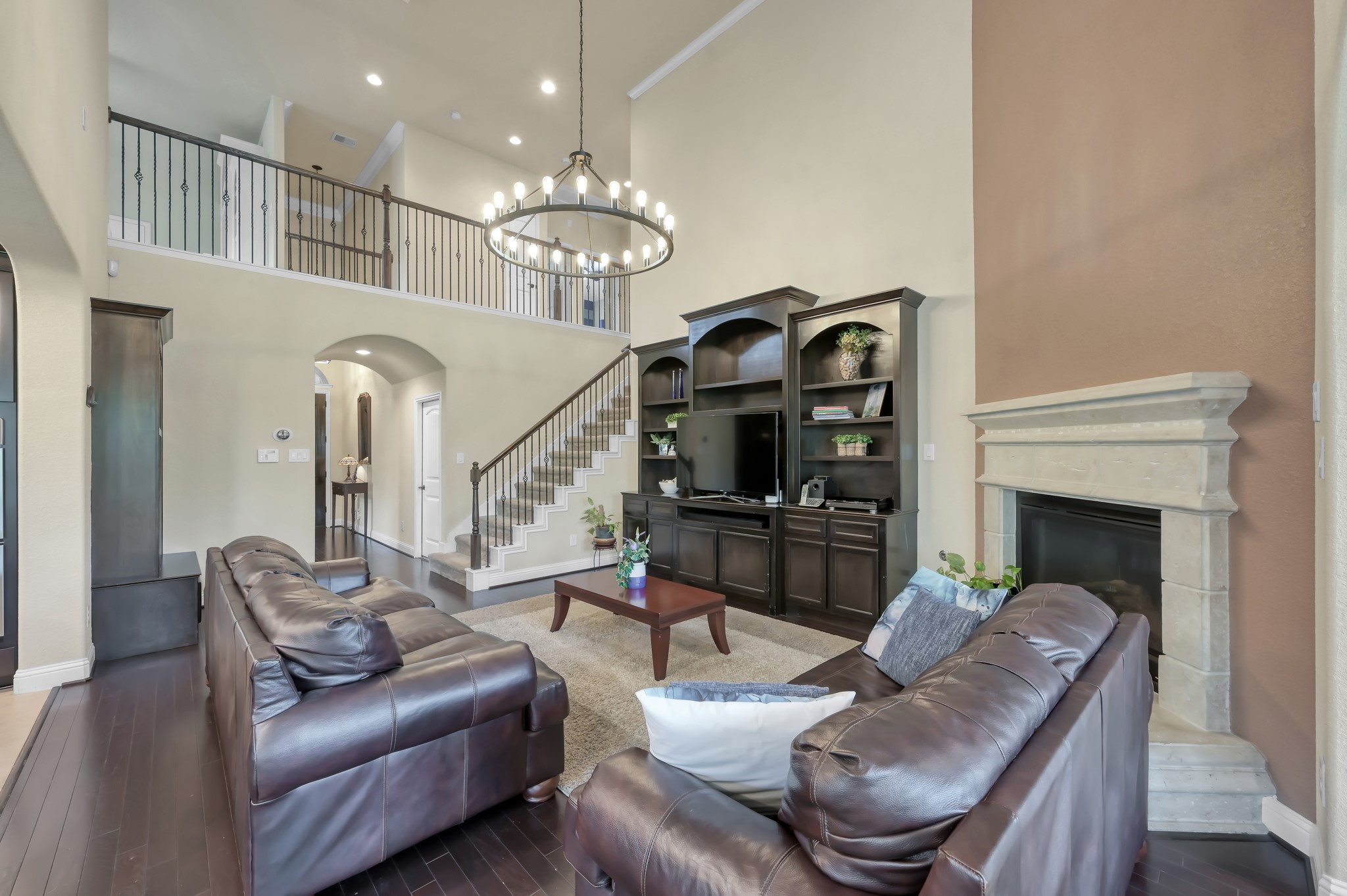 23 Rancher's Trail Tomball, TX 77375 - Photo 6 of 40 Experience the inviting warmth of this spacious living room, featuring ample natural light, elegant dark wood accents, and a cozy fireplace perfect for relaxation and entertaining.