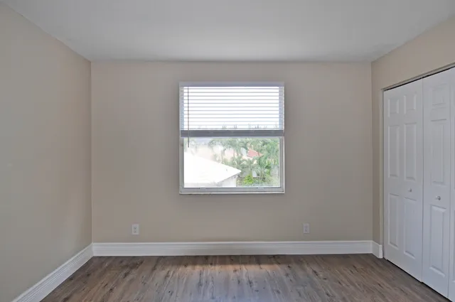 a bathroom with a granite countertop toilet sink and mirror