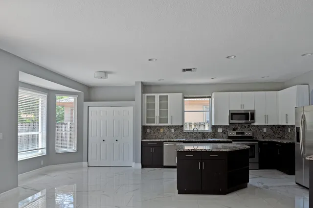 a kitchen with granite countertop a sink and cabinets