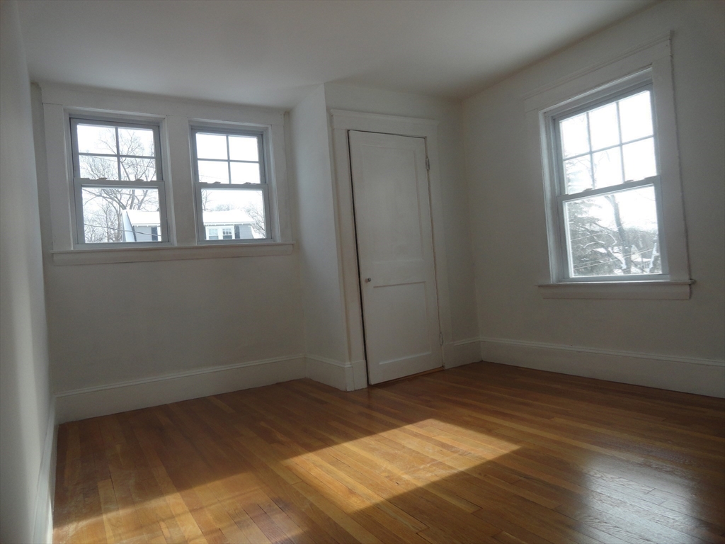 14 Rowe Hill Road Stoneham, MA 02180 - Photo 22 of 30 an empty room with wooden floor and windows