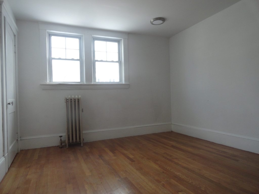 14 Rowe Hill Road Stoneham, MA 02180 - Photo 24 of 30 an empty room with wooden floor and windows