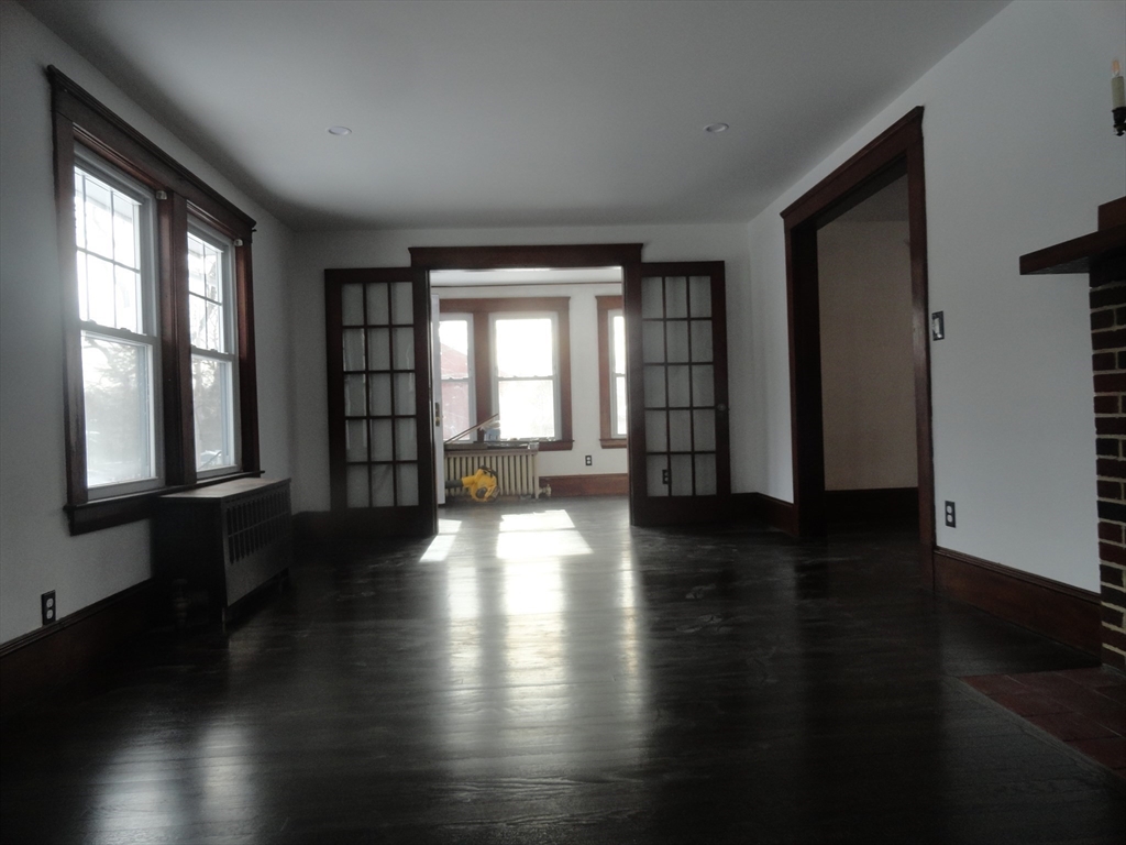 14 Rowe Hill Road Stoneham, MA 02180 - Photo 5 of 30 a view of an empty room with wooden floor and a window