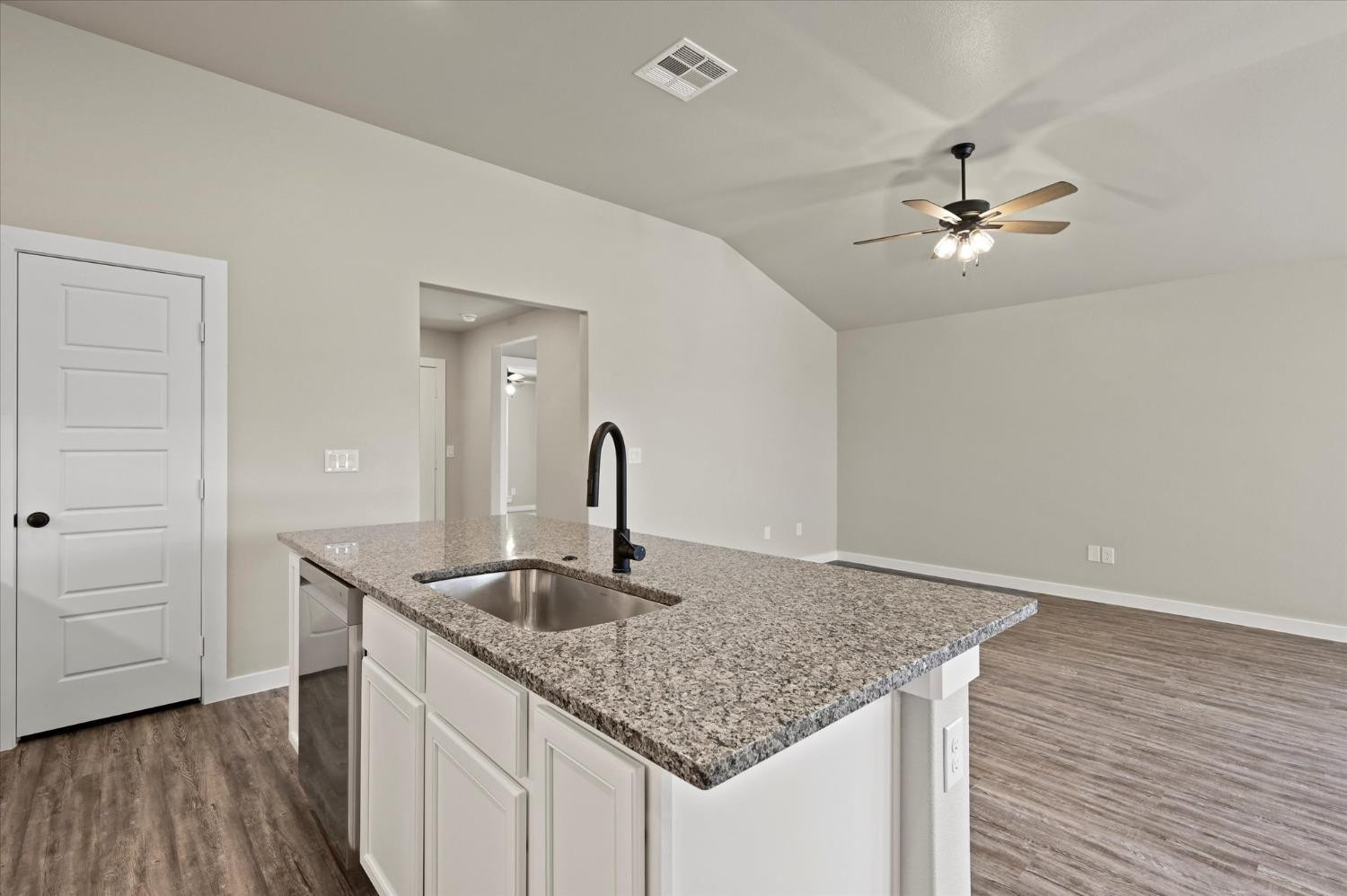 3706 Urbana Place Lubbock, TX 79407 - Photo 11 of 22 a kitchen with granite countertop a sink cabinetry and wooden floor