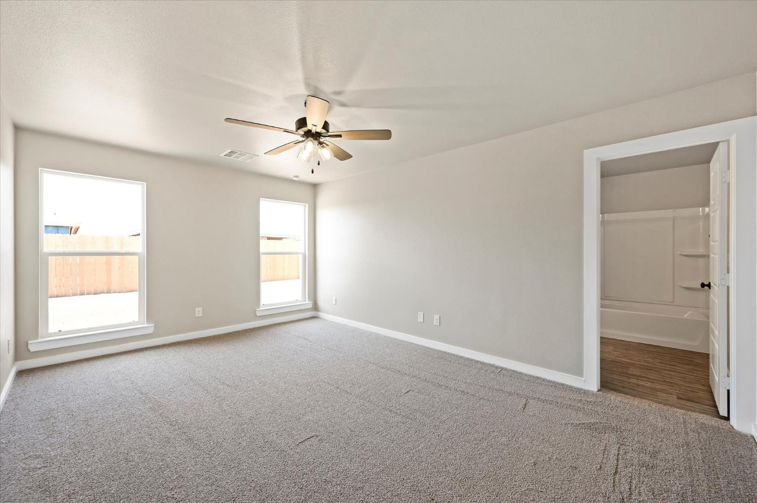 3706 Urbana Place Lubbock, TX 79407 - Photo 12 of 22 an empty room with windows and chandelier fan