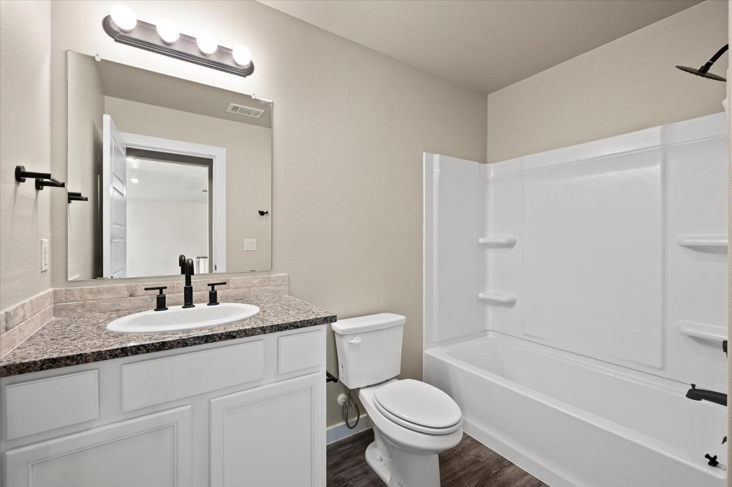 3706 Urbana Place Lubbock, TX 79407 - Photo 19 of 22 a bathroom with a granite countertop sink toilet and shower