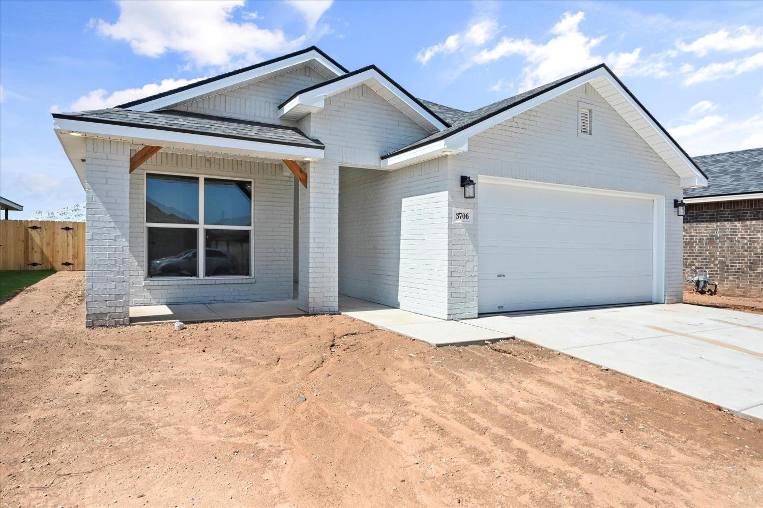 3706 Urbana Place Lubbock, TX 79407 - Photo 2 of 22 a front view of a house with a yard and garage