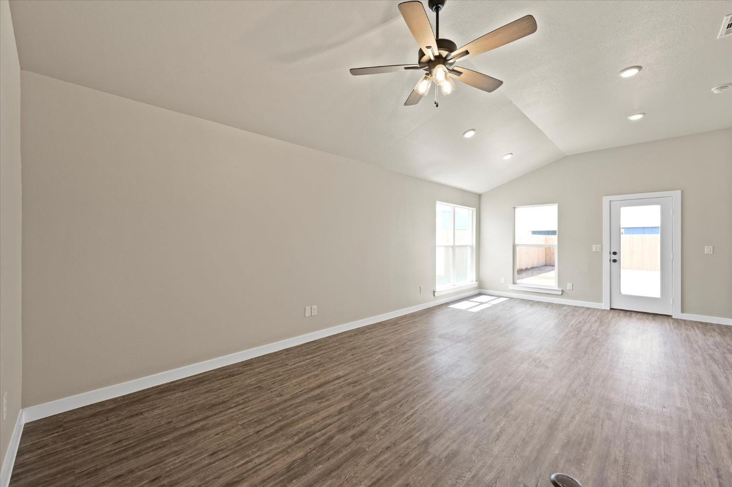 3706 Urbana Place Lubbock, TX 79407 - Photo 4 of 22 a view of an empty room with window and wooden floor