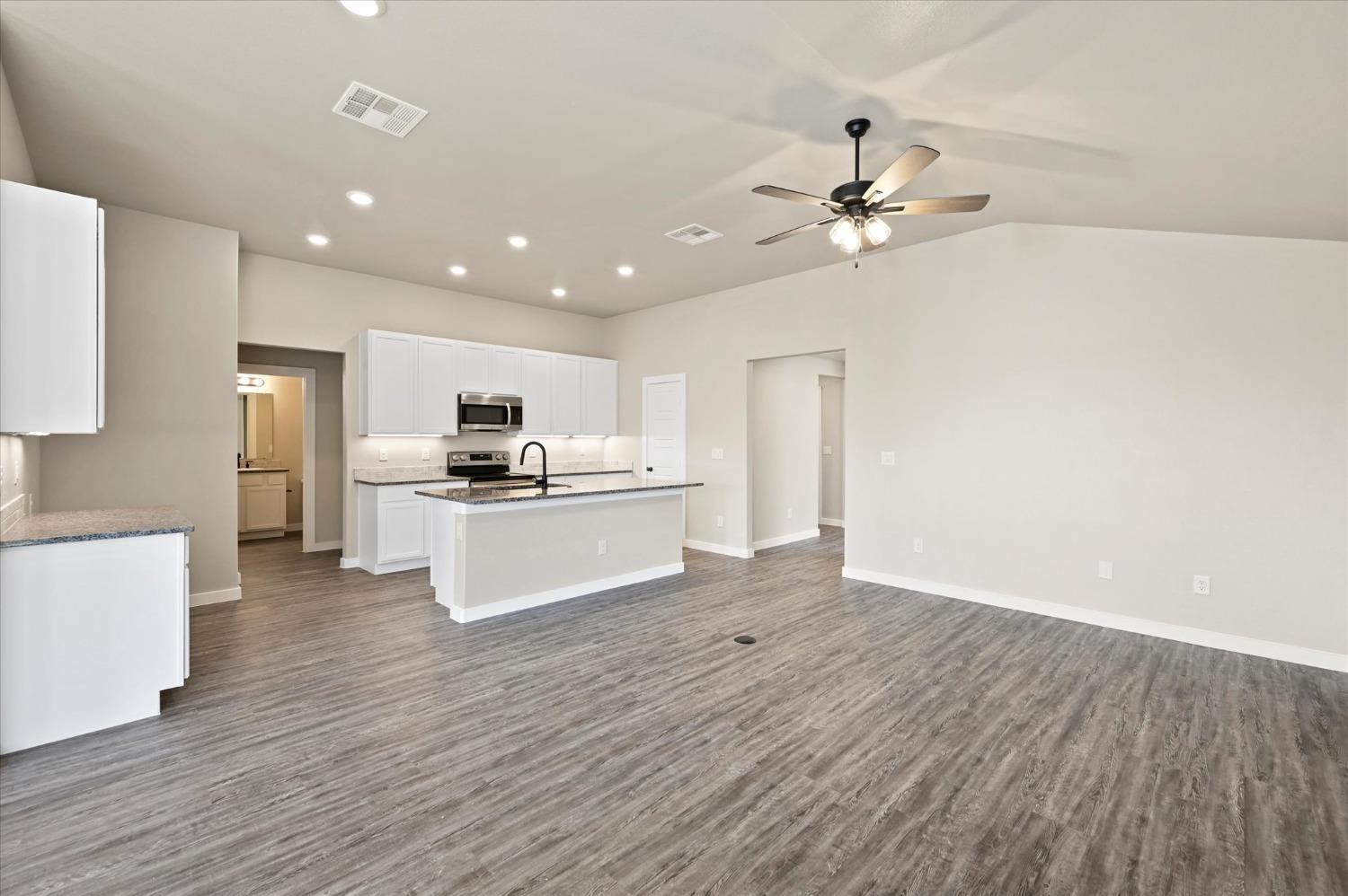 3706 Urbana Place Lubbock, TX 79407 - Photo 6 of 22 a kitchen with kitchen island white cabinets and stainless steel appliances