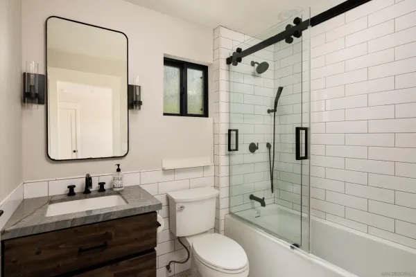 a bathroom with a granite countertop sink toilet and shower