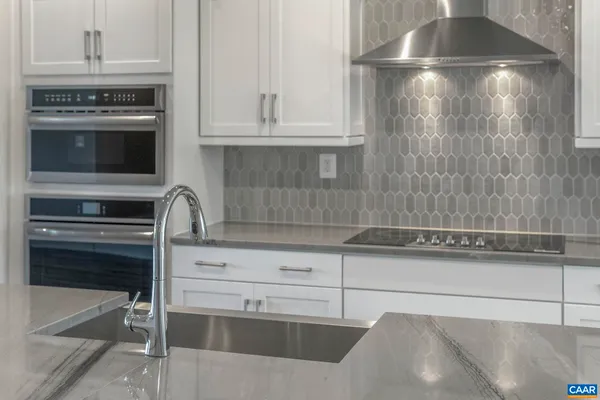 a kitchen with granite countertop a stove and cabinets