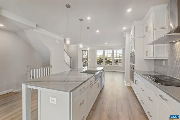 a kitchen with granite countertop a sink stove and refrigerator