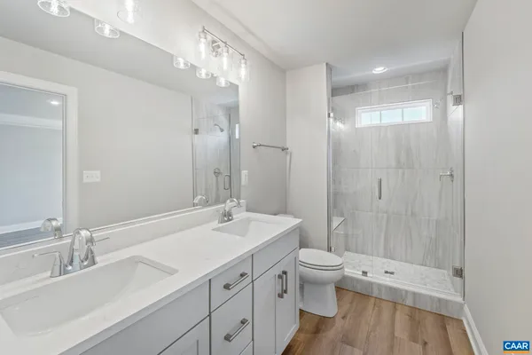 a bathroom with a double vanity sink toilet and shower