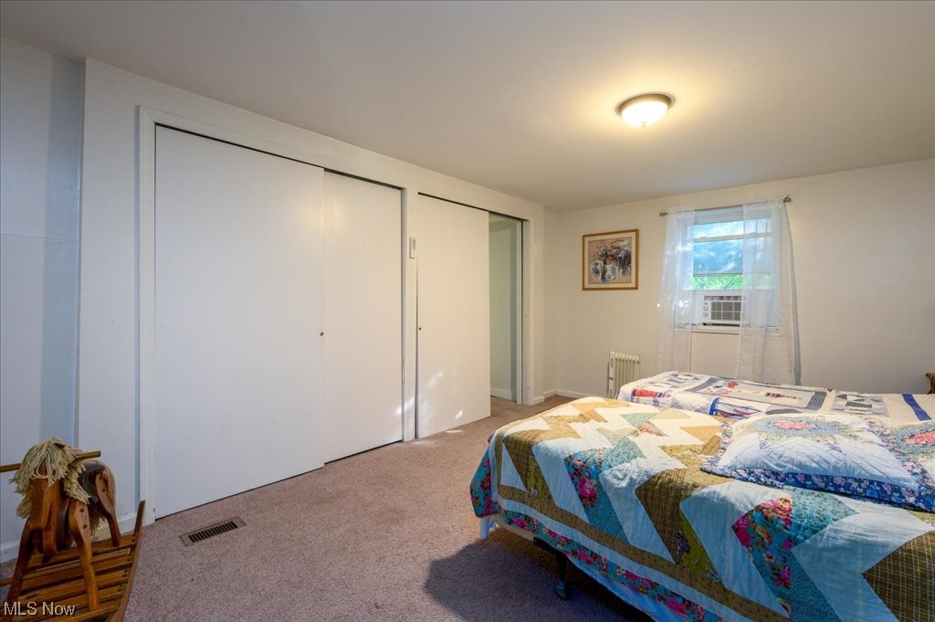 2641 Tower Road Jefferson, OH 44047 - Photo 18 of 35 Bedroom with light carpet, radiator, and two closets