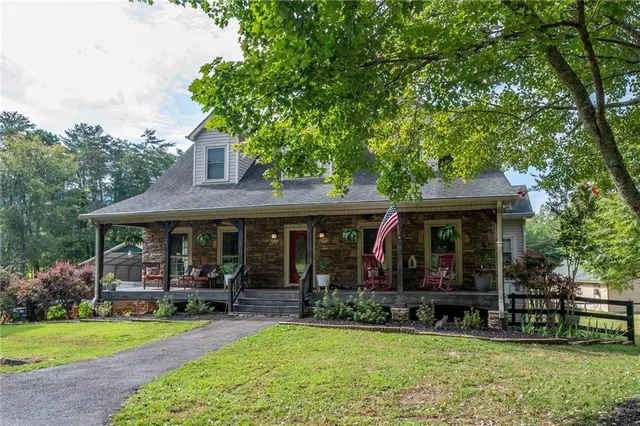 a view of house with a outdoor seating area and garden