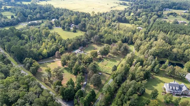 a view of a house with a yard and a large tree