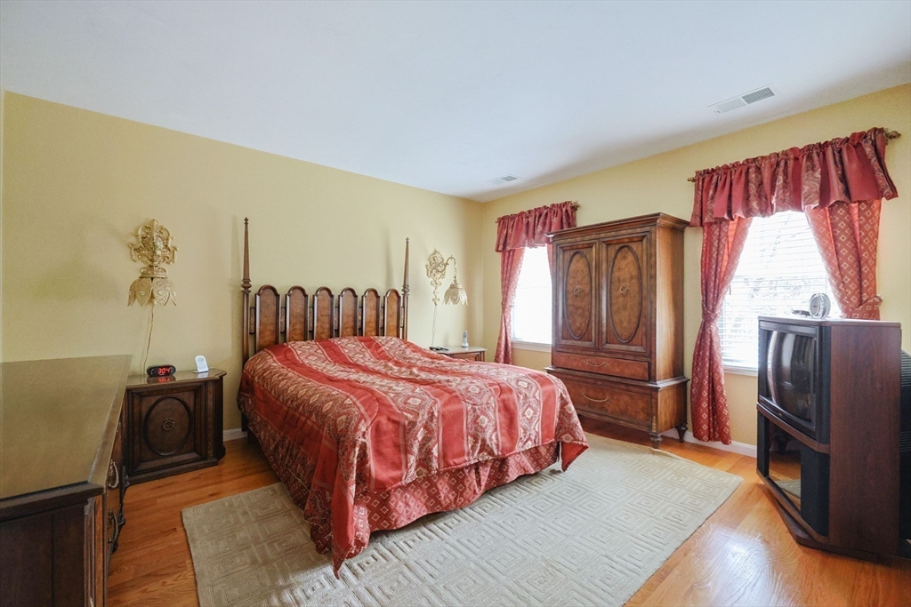 14 Codding Road, Unit 65 Norton, MA 02766 - Photo 20 of 30 a bedroom with a bed dresser and a refrigerator