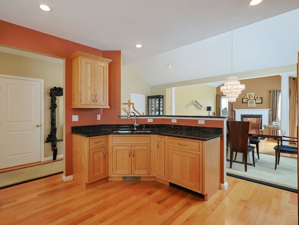14 Codding Road, Unit 65 Norton, MA 02766 - Photo 5 of 30 a kitchen with granite countertop a stove a sink and a wooden cabinets