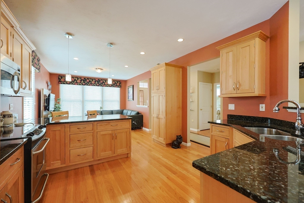 14 Codding Road, Unit 65 Norton, MA 02766 - Photo 6 of 30 a kitchen with stainless steel appliances granite countertop a stove a sink and a microwave