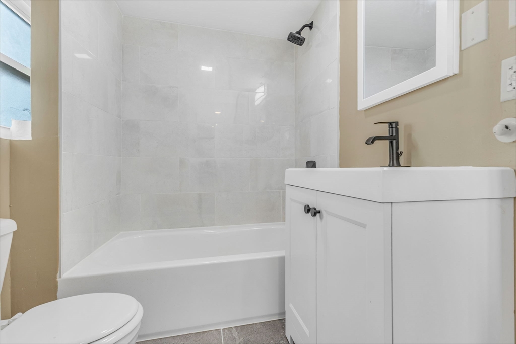 18 School Street, Unit 2 Boston, MA 02119 - Photo 13 of 23 a bathroom with a bathtub shower sink vanity and toilet